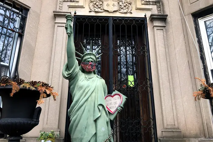 A photo of statue of liberty wearing bandana around mouth